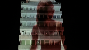 Shadow of a person projected onto a multi-story building at night
